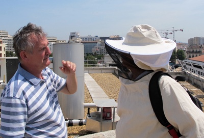 Sur le toit de l'Hôtel de Région, Henri Clément visite les ruches "urbaines" (photo MN)